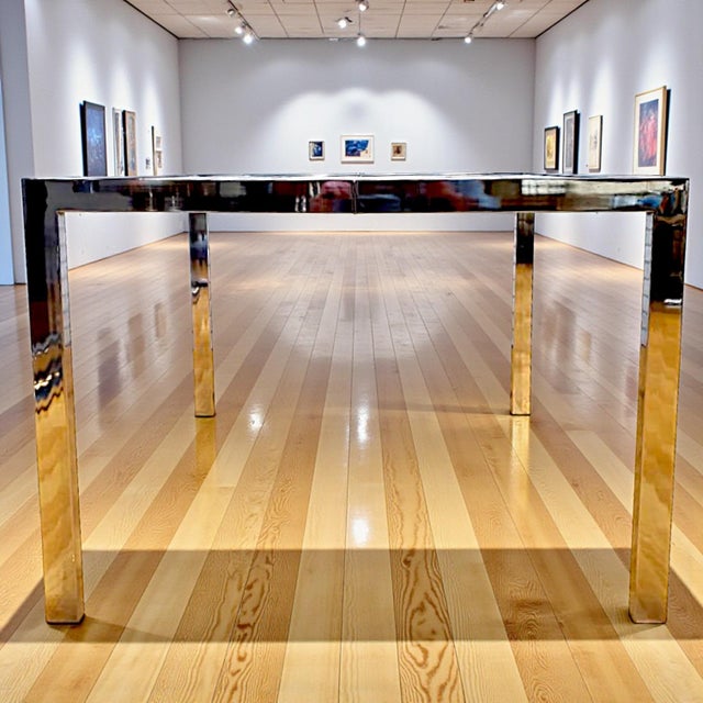 Stunning polished chrome steel and glass dining table by Milo Baughman for DIA. Inset glass with chrome trim on parsons...