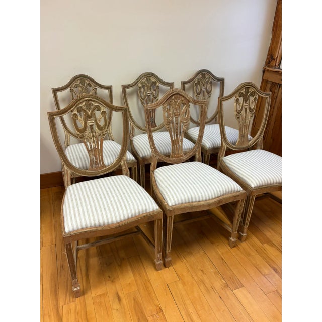 A beautiful set of six Sheraton style dining side chairs in a gorgeous distressed painted finish. The shield backs...