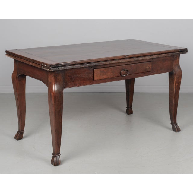 The top is made of two hinged planks that rotate and slide to one side and then unfolds. When closed, it can function as a...