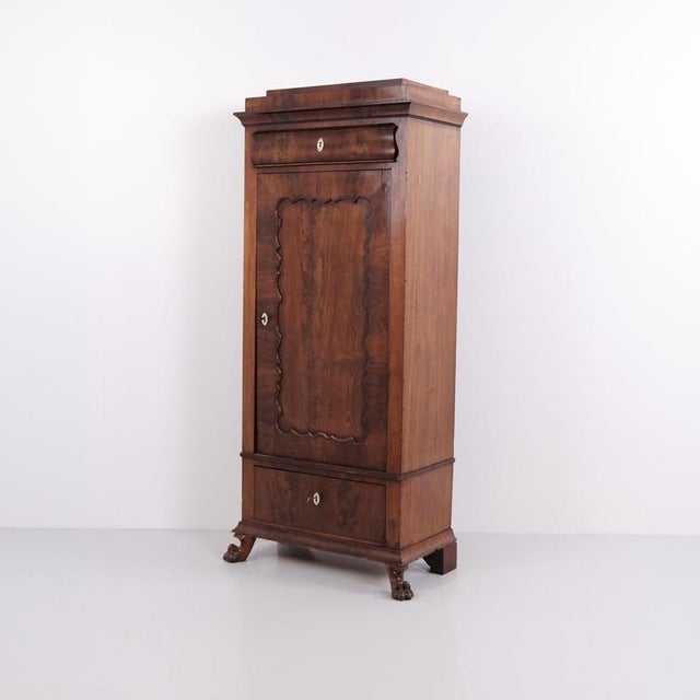 Antique silverware cabinet crafted from hand-polished mahogany with a cabinet door and decorative lion feet. The cabinet...