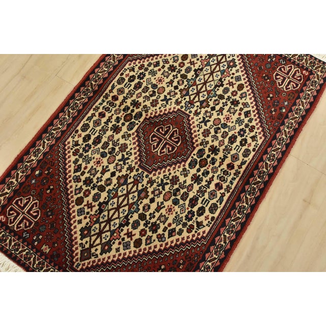 An authentic vintage tribal Abadeh rug hand-knotted with fine wool and natural dyes. This intricately woven rug features a...
