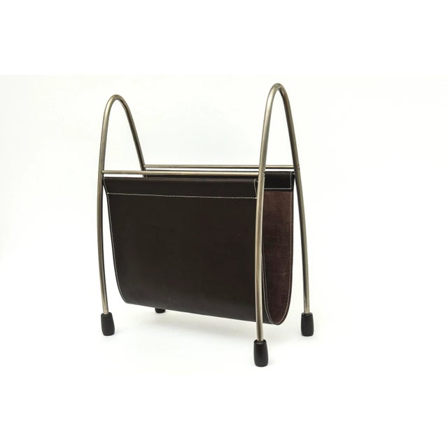 This handsome free standing brown leather and white stitched magazine stand is brushed stainless steel with black rubber...