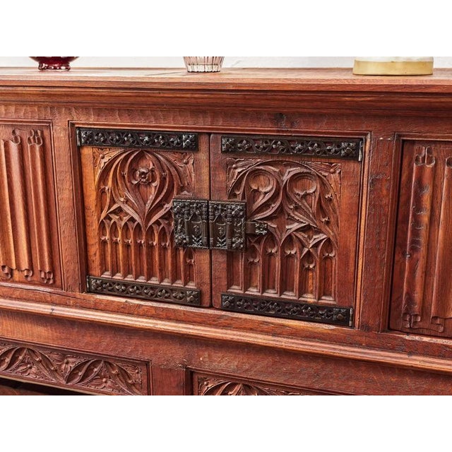An impressive chest of drawers made of high-quality solid oak, which stands out for its precise carving work in the Gothic...