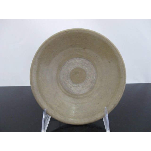 Chinese Longquan style small celadon pottery bowl. Small tea bowl with thick green-gray tone glazed pottery with unglazed...