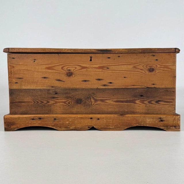 A characterful 20th-century English storage chest, well crafted from pine and distinguished by its generous storage...