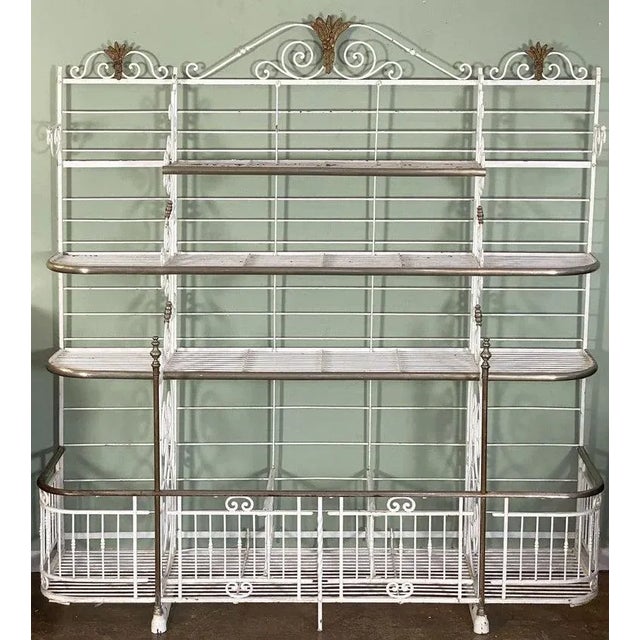 A large French baker's rack boulangerie or patisserie display stand of painted wrought iron with decorative brass and...