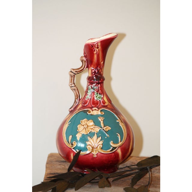 This little porcelain majolica ewer pitcher is hand-painted and nicely glazed, it stands 8" tall and is in very good...