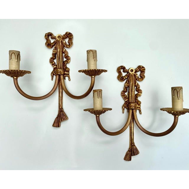 Pair of vintage French wall sconces. Mid 20th Century. These stunning pieces are crafted from richly gilded bronze,...