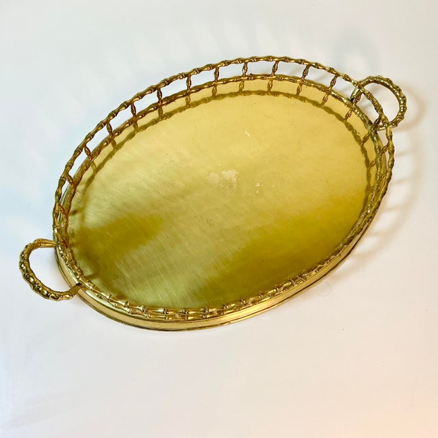 Vintage Home is pleased to present this large oval brass serving tray with a faux bamboo gallery edge and side handles....