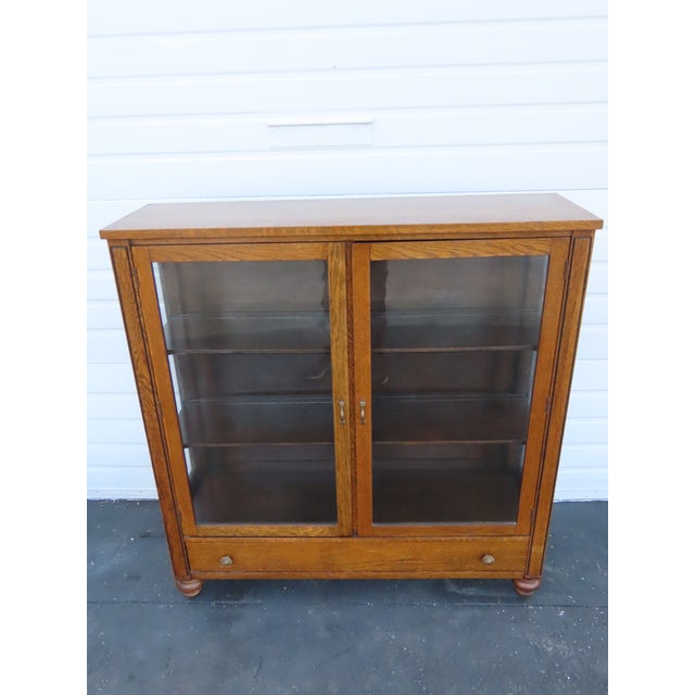This brilliant Cabinet is made of wood, solid wood, oak, tiger oak, glass, and metal. It was made by Peck & Hills...