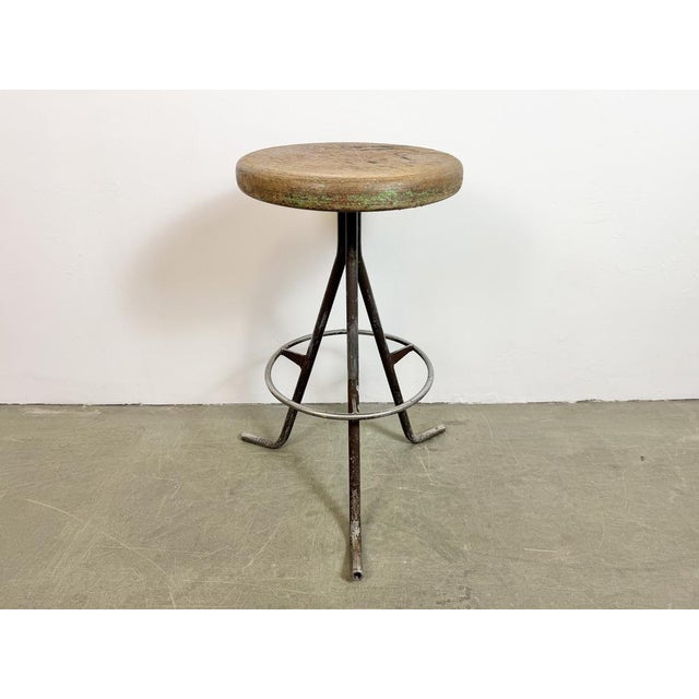 Vintage Industrial factory stool made in former Czechoslovakia during the 1960s It features a wooden seat and a grey iron...
