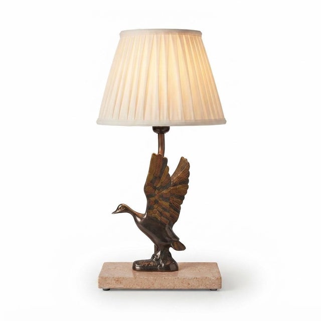 Decorative table lamp dating to the 1970s, featuring a duck with raised wings in bronze-toned metal. The textured feathers...