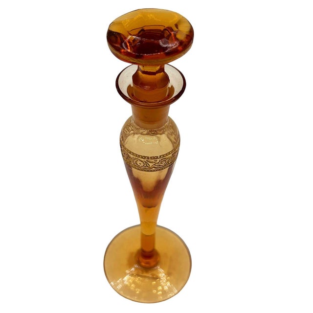 An exquisite Art Deco perfume bottle crafted in a luminous, warm amber peach glass. with a slender, elongated silhouette,...
