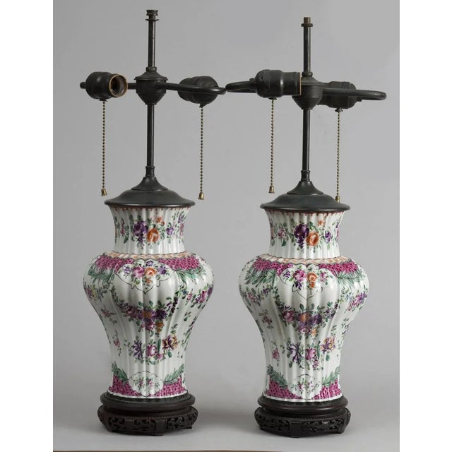 Pair of Samson porcelain baluster-shaped vase lamps on original antique Chinese pierced wooden stands. The body is ribbed...