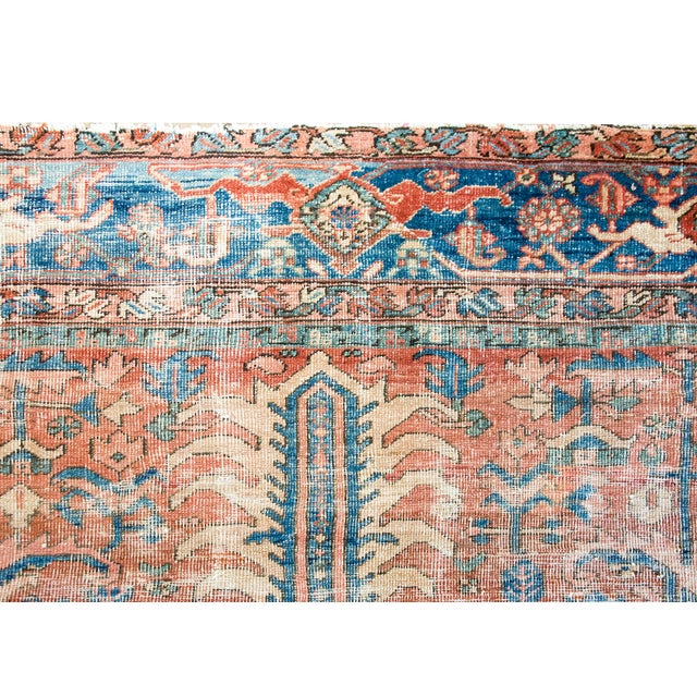 This antique Persian Heriz rug features a classic geometric composition with a bold central medallion and angular...