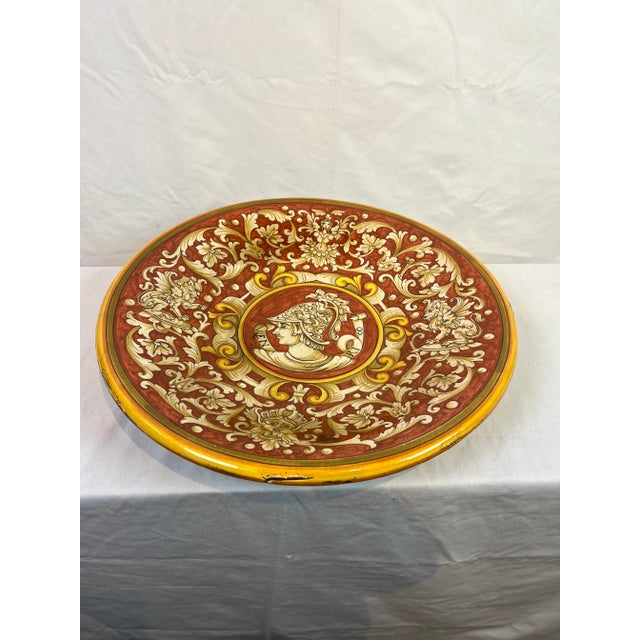 Pair of Hand painted round ceramic plates in paprika, ivory and yellow colors featuring a right and left facing male...