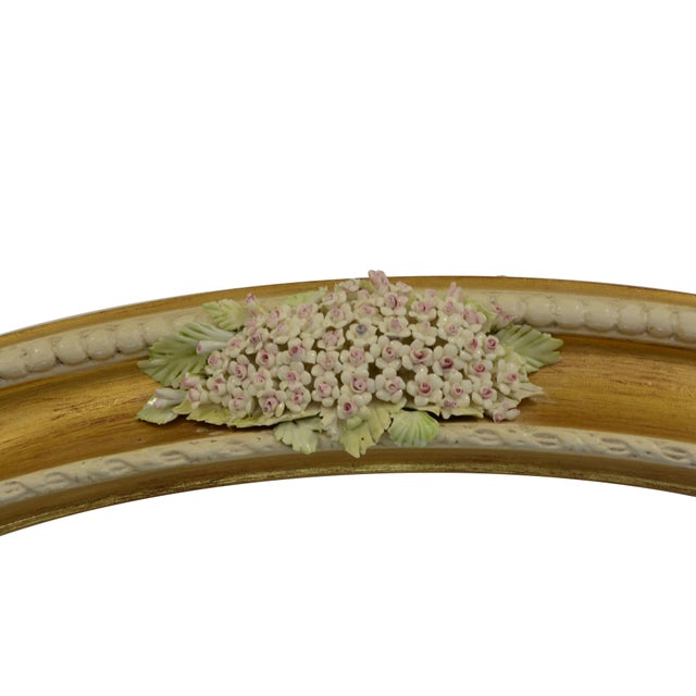 Elegant Italian oval wall mirror by Giulio Tucci, featuring a refined wooden frame with a warm gilt finish and exquisite...