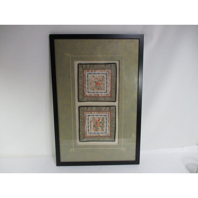 Vintage black wood framed pair of Chinese silk embroidery gold panels, decorated with floral designs in colors of green...
