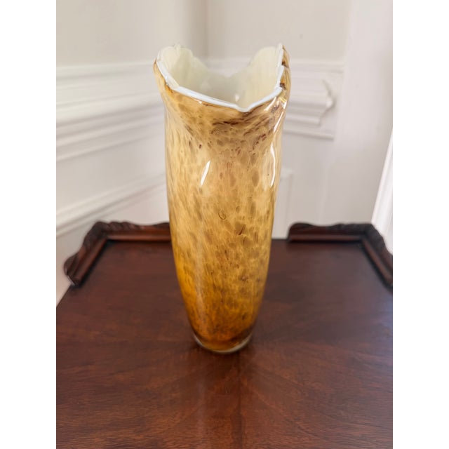 Handblown vintage art glass vase in a striking flared trumpet form, featuring warm amber and honey tones that deepen...