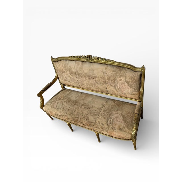 Elegant Louis XVI–style giltwood settee featuring refined neoclassical proportions and finely carved detailing throughout....