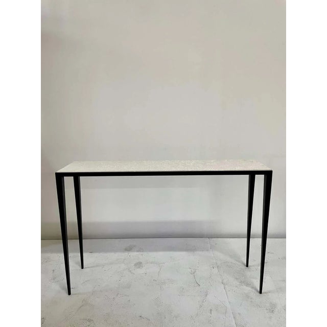 After an iconic design by JMF, this sleek console table features tapering legs with a beautifully textured limestone top...