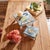 Add a charming touch of nature to your home with the Wooden Floral Bird Pedestal Tray Set. Featuring cool blue and white...