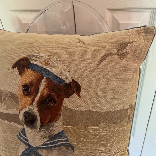 Sailor dog on a coastal beach background with seagulls and a hat with a gold anchor. This Tapestry pillow was woven by...