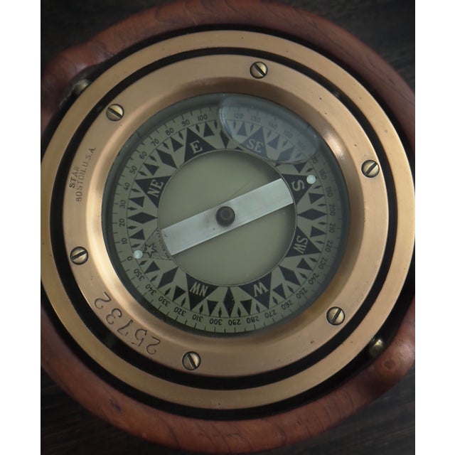 Housed in a solid turned wood case, this nautical deck compass features a true gimbaled brass mechanism and is...