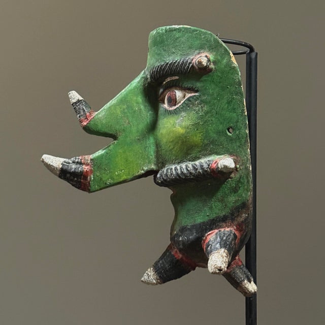 A hand carved and polychrome green painted wooden mask from the Guerrero region of Mexico, depicting a horned, bearded...