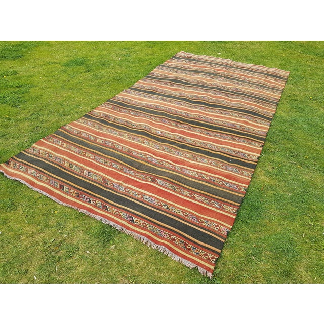 This is a vintage handwoven Turkish kilim rug. The piece is from the 1970s.