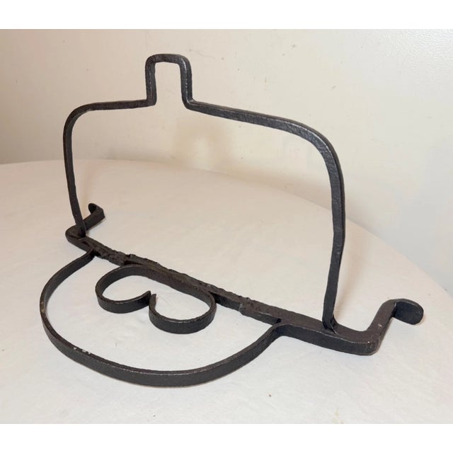 This rare antique 17th century handmade wrought iron hanging fireplace trivet is a unique piece of architectural history....