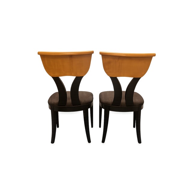 A striking pair of dining chairs by Pietro Costantini, blending a curved klismos-inspired silhouette with a modern...