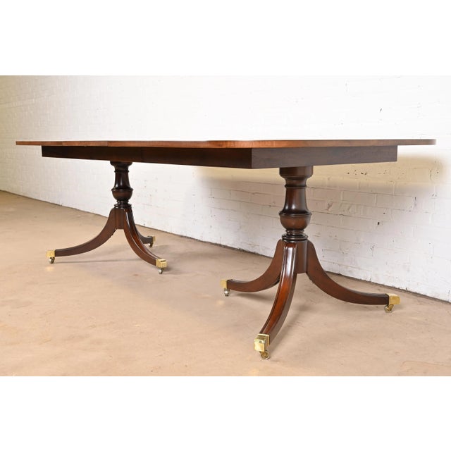 An exceptional Georgian or Regency style double pedestal extension dining table In the manner of Baker Furniture USA,...