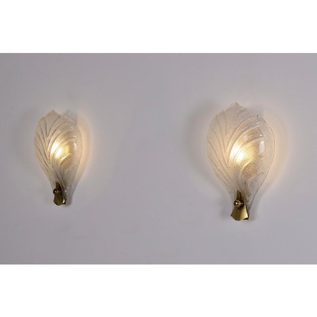 Pair of murano glass wall sconces, shaped like leaves with pronounced veins, their deep curve reminiscent of a chalice....