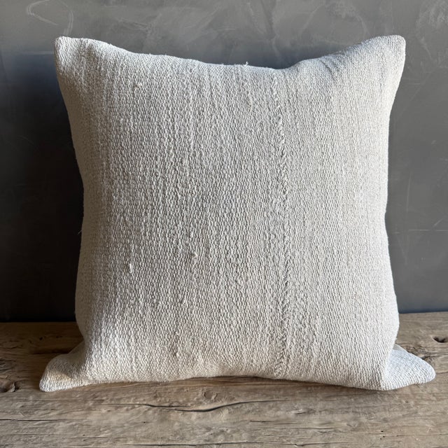 Creamy white hemp rug pillow with original seams. Soft hand, linen blend backing with zipper closure. Spot cleaning is...