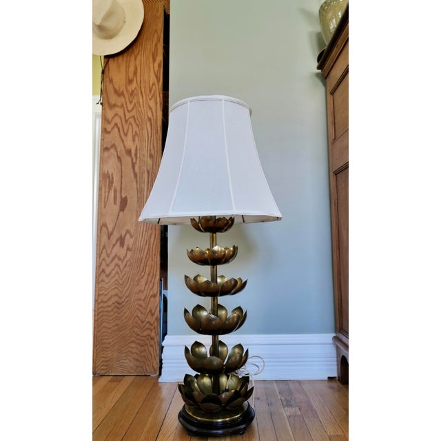 A stunning 1960s brass lotus lamp with tiered petals stacked the full length of the stem, a black lacquered wood base,...
