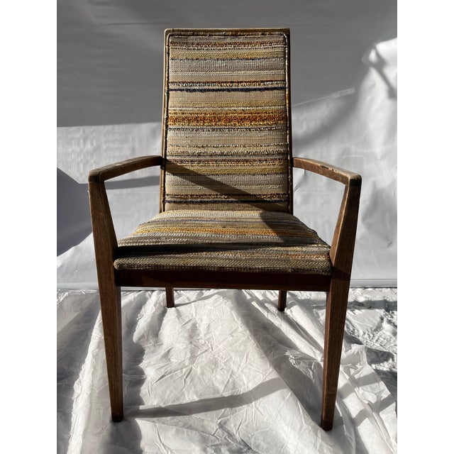 A single Merton Gershun for Dillingham furniture walnut dining arm chair with woven upholstered seat and back.
