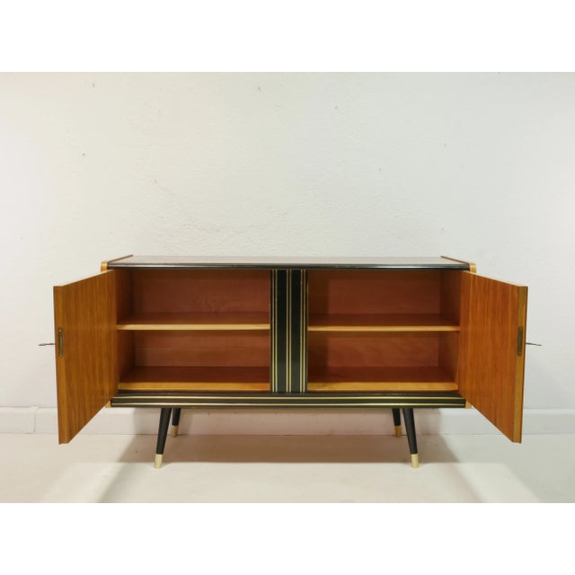 This original vintage sideboard from the 1960s combines timeless mid-century design with functional elegance. The surfaces...