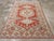 This mid-20th-century Persian Veece accent rug presents a bold geometric composition across a warm rust-red field. The...