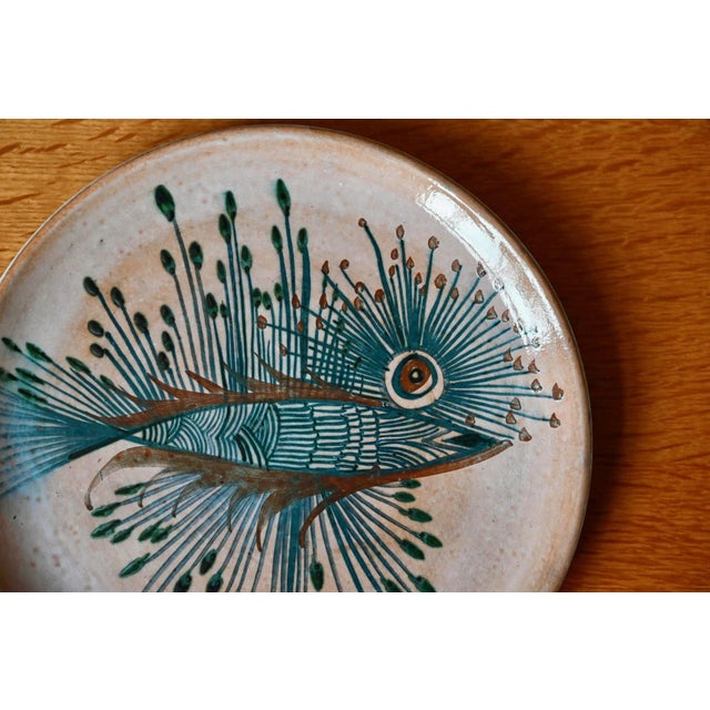 Let yourself be captivated by the hypnotic gaze of this fantastical fish! This magnificent decorative ceramic plate is an...