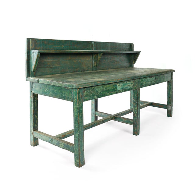 Skated wooden workshop table with its green shelf. Work furniture.