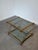 Elegant vintage side table combining clear acrylic glass legs with polished brass frames and corner fittings. A classic...