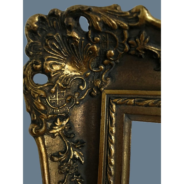 A beautifully sculpted French giltwood frame featuring elaborate floral ornaments, scrolling foliage and decorative relief...