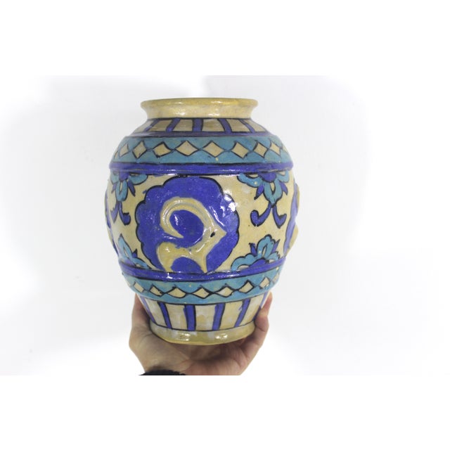 Charming primitive clay vase with a raised ram motif. Hand painted blue and turquoise. No damage, but has some crazing in...