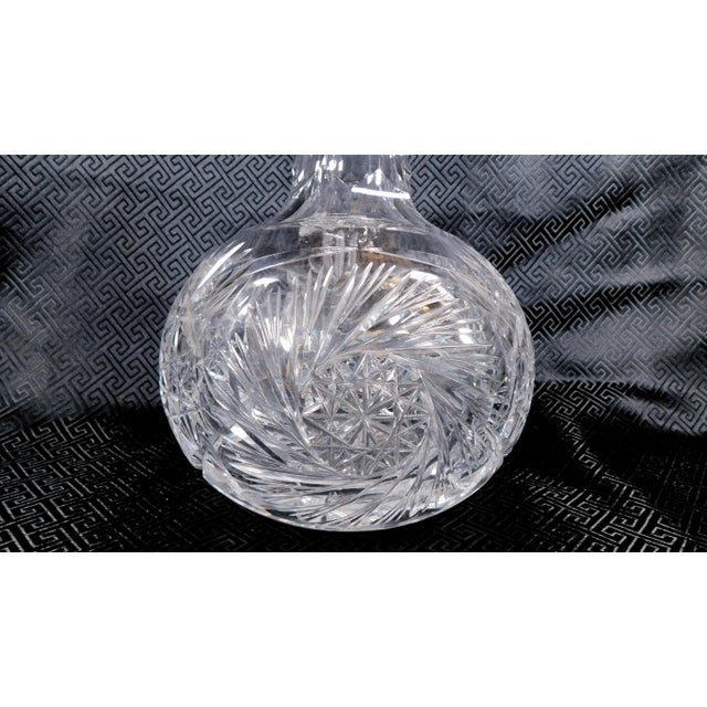 This is a very heavy (Three pounds, thirteen ounces) cut crystal carafe with a whirling star pattern. The bottom is badly...