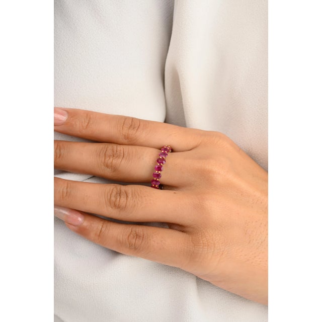 This is part of Chairish’s Fine Jewelry assortment. 4.67 Carat Ruby Birthstone Eternity Band Ring in 14K Gold symbolizes...