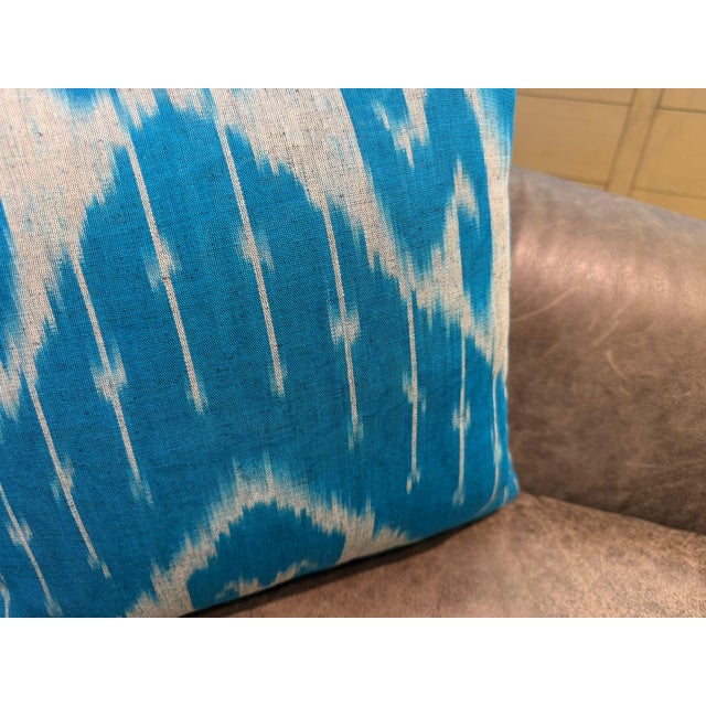 Multiple white columns descend vertically across a sky blue silk ground, each one narrowing into a fine drip before...
