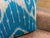 Multiple white columns descend vertically across a sky blue silk ground, each one narrowing into a fine drip before...