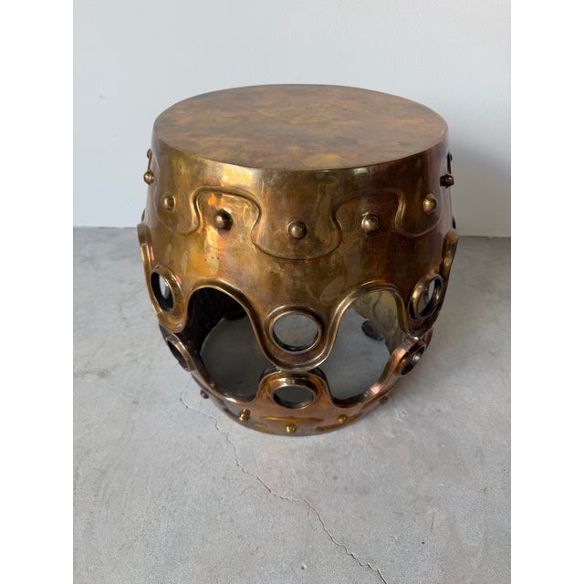 A bold and sculptural solid brass side table by Jonathan Adler, featuring a striking cylindrical form with architectural...