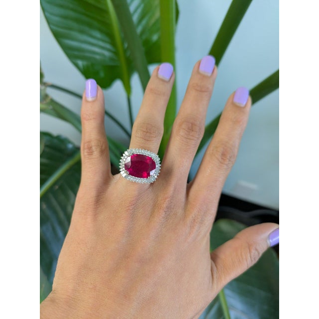 A remarkable 12.04-carat Madagascar ruby glows in a deep, warm red at the centre of this solid two-tone 14K white and...